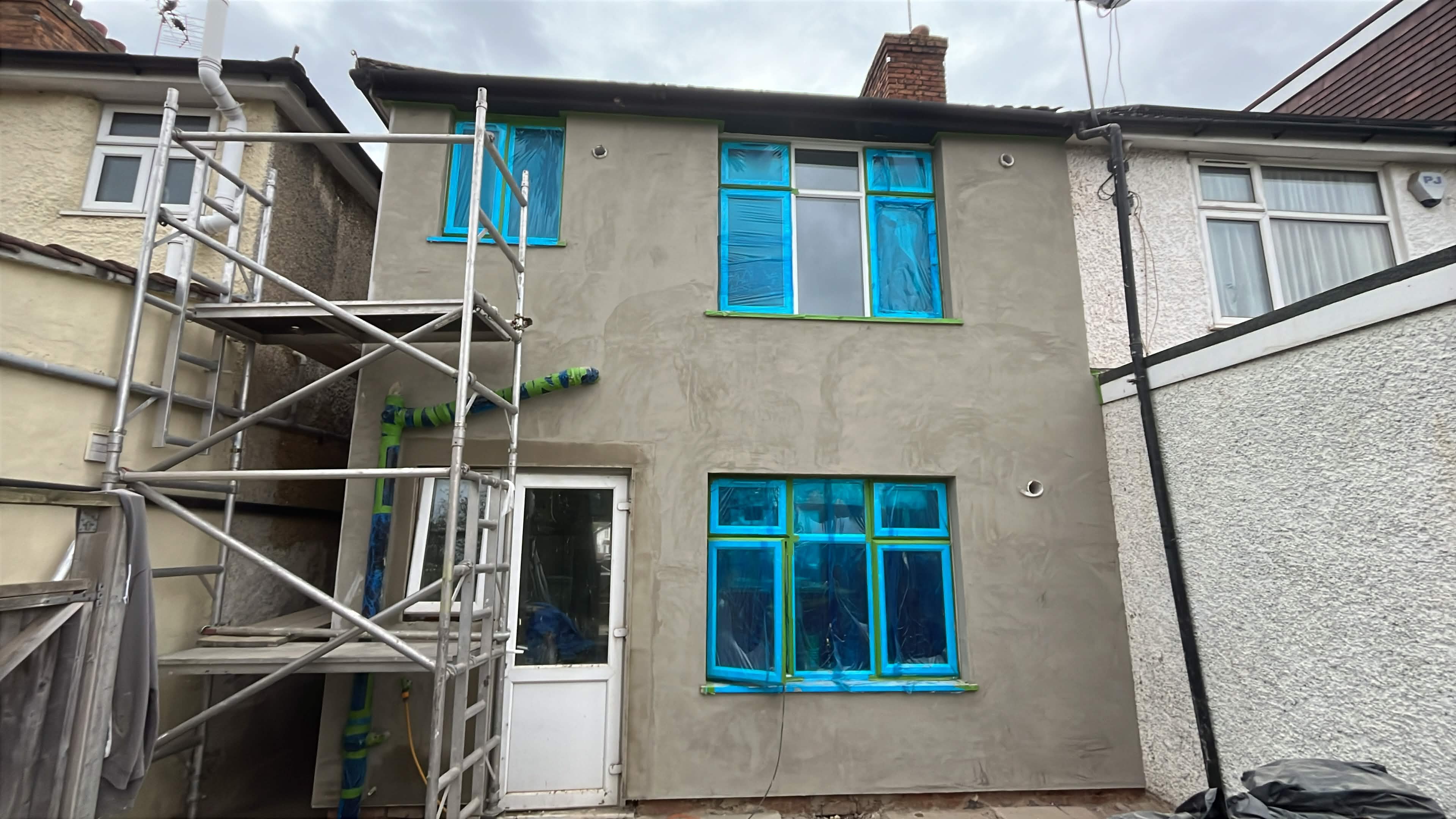 House No. 1 back elevation adhesive and mesh layer progress